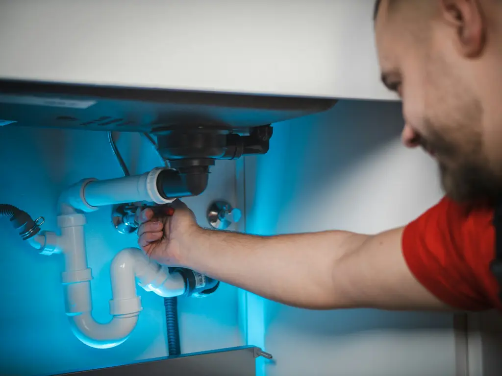 Lavabo altı sifon bağlantısını kontrol eden tesisatçı